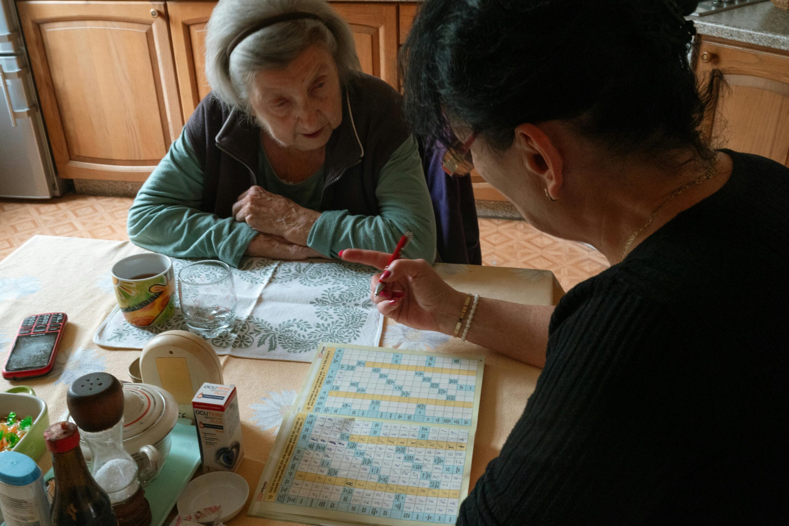Aktivierung Betreuung zu Hause Seniorin löst Kreuzworträtsel mit Betreuungskraft